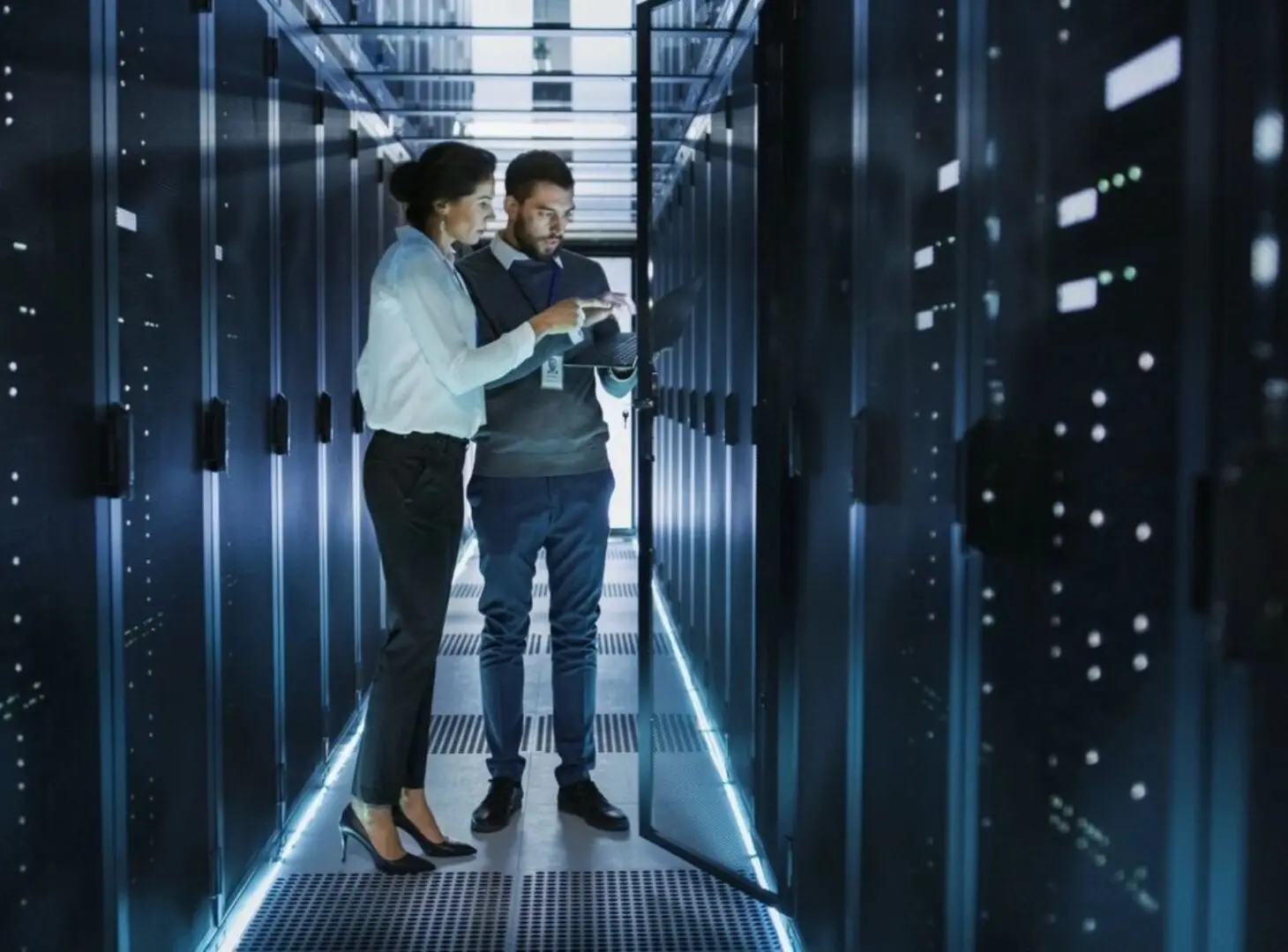 Two people standing in a room with some servers