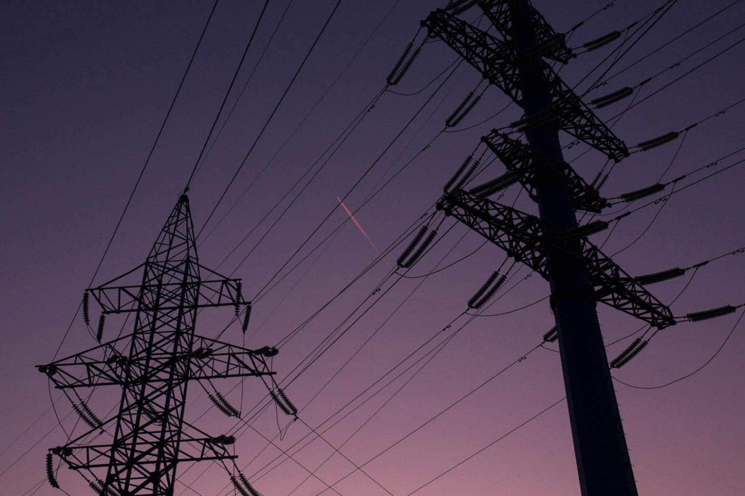 A purple sky with power lines and some wires