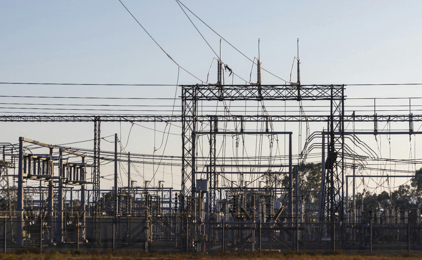 A large power plant with many wires hanging from it.